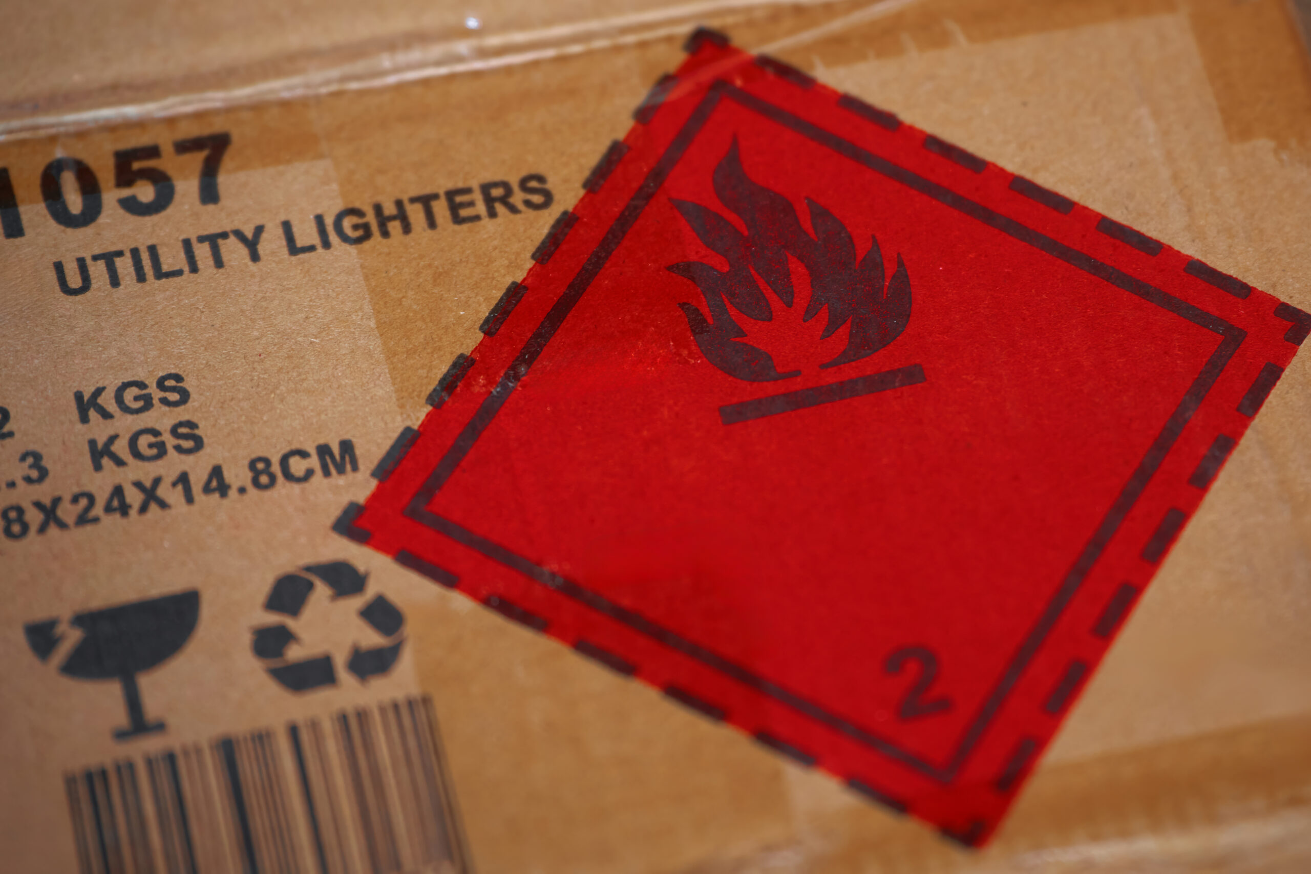 Red flame hazard label on a brown cardboard box